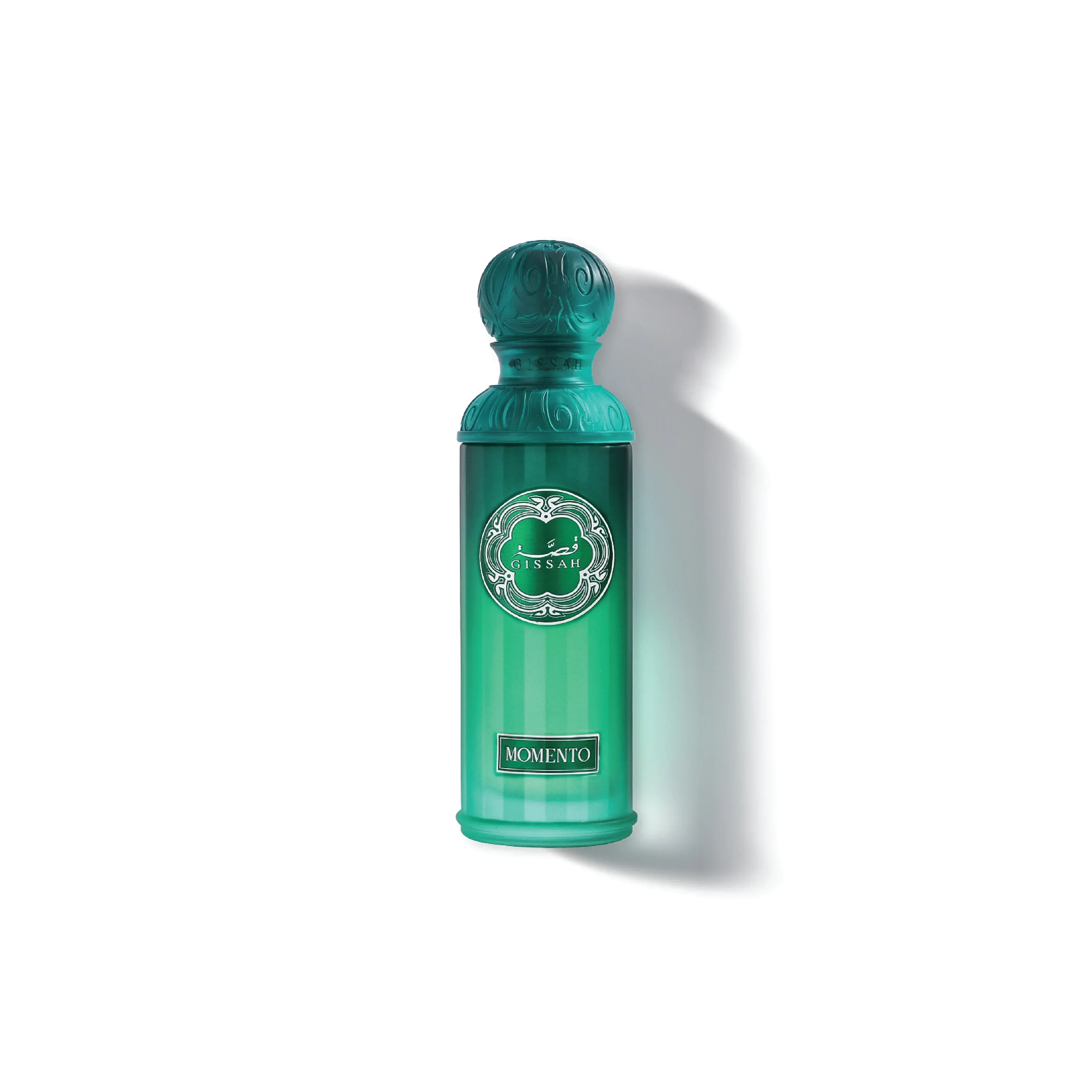 Green Gissah Momento perfume bottle with ornate cap on white background.