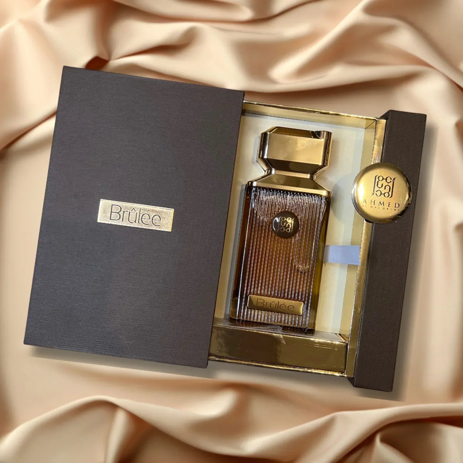 Brûlée perfume in a gold and brown luxury gift box on a satin background