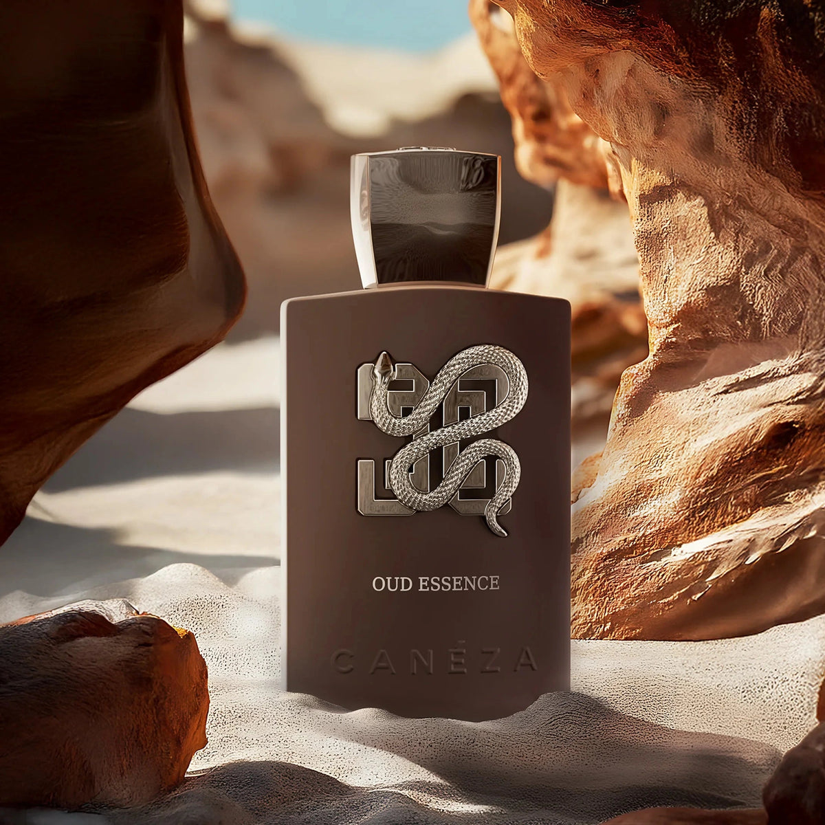 Perfume bottle labeled 'Oud Essence' on a rocky desert background
