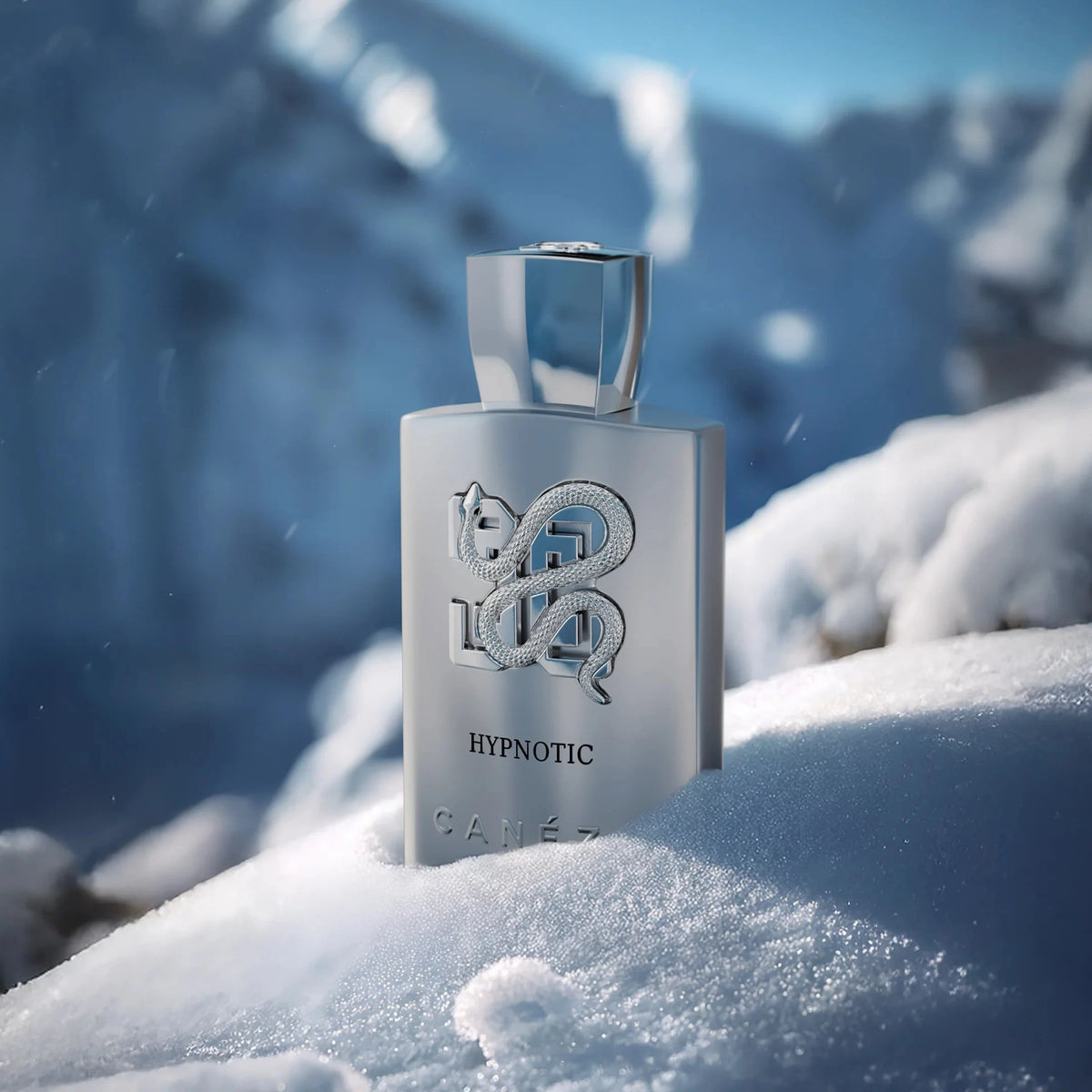 Silver bottle labeled 'Hypnotic' on a snowy landscape with mountains in the background