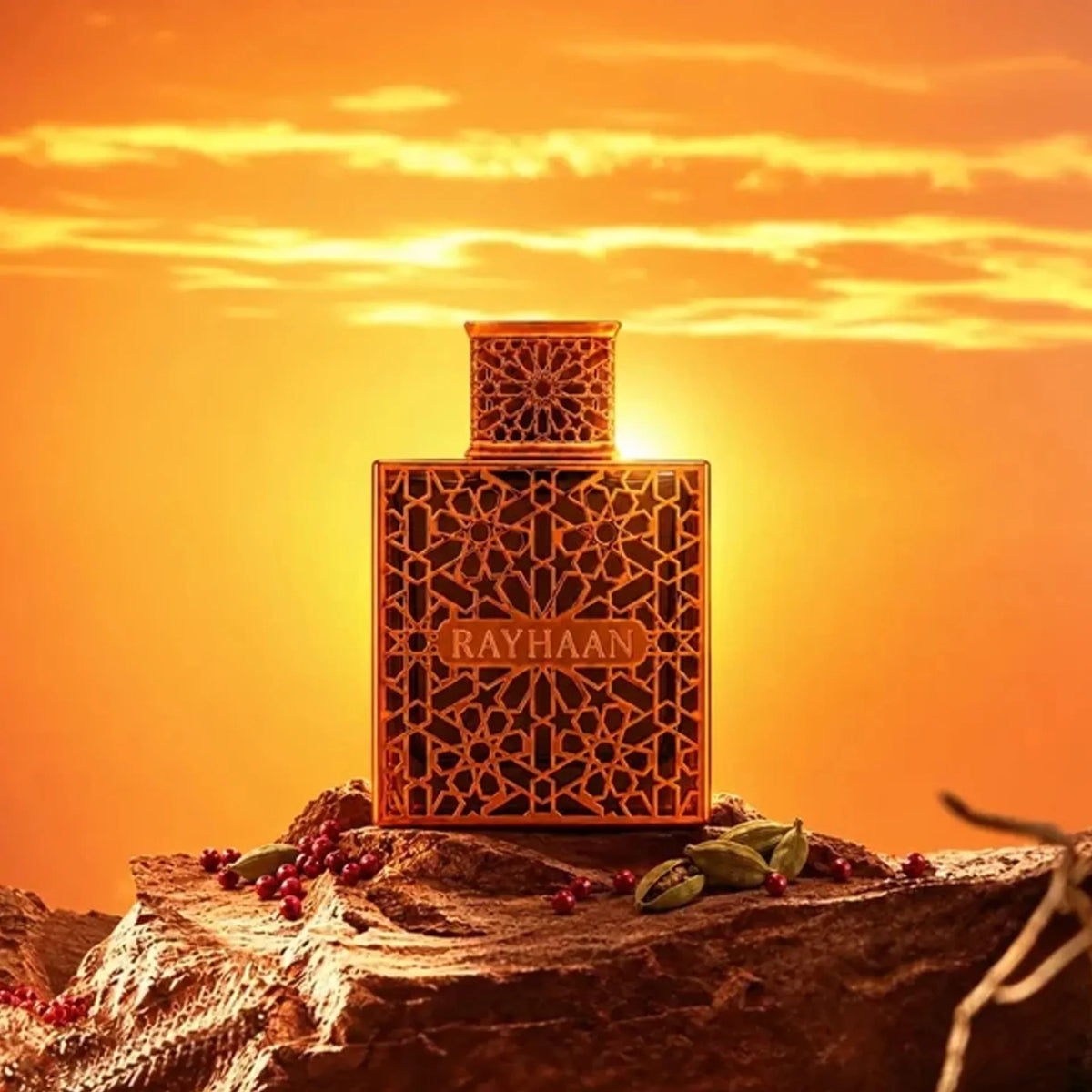 Rayhaan Vantage 100ml perfume bottle with intricate gold lattice design, set on a rocky surface against a sunset background.